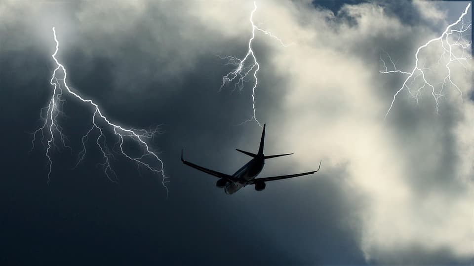 Flugzeug vor Gewitterwolken mit Blitzen